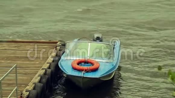 暴风雨中码头的一艘小船在海浪中颠簸视频的预览图
