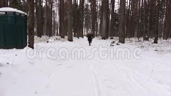 女孩在冬天的森林里奔跑视频的预览图