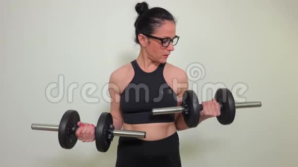 两个哑铃做二头肌锻炼的女人视频的预览图