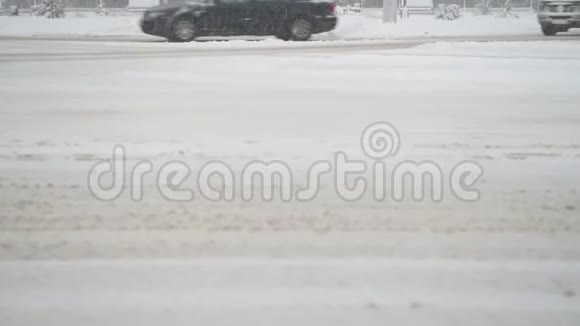 城市的冬季道路汽车骑着车穿过积雪的十字路口视频的预览图