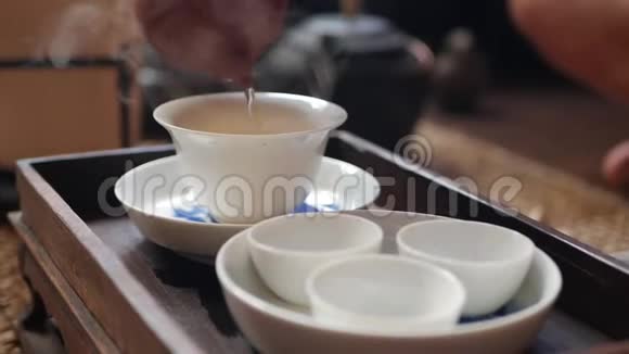 中国传统的功夫或功夫茶道茶师将绿茶倒入盖湾或钟构成部分视频的预览图