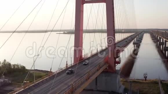 空中飞行在夕阳下通过一座斜拉桥站在河的上方4k视频的预览图