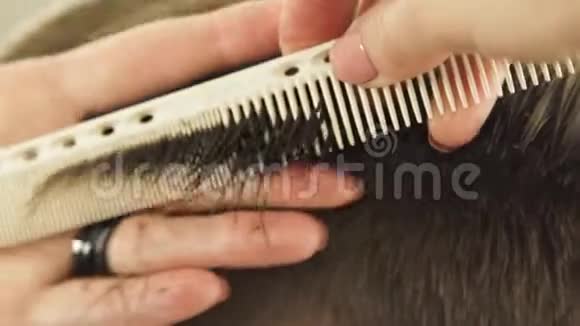 手工理发师梳理湿发并使用美发剪刀进行剪短理发师做男性发型视频的预览图
