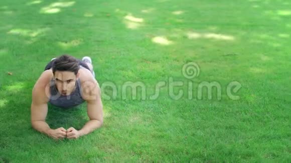 体育夫妇在夏季公园的草地上一起锻炼木板视频的预览图