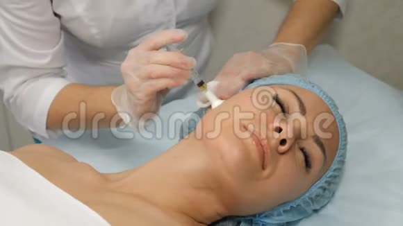 美的概念正在进行的中间治疗程序美容师拿着注射器与女性一起工作视频的预览图