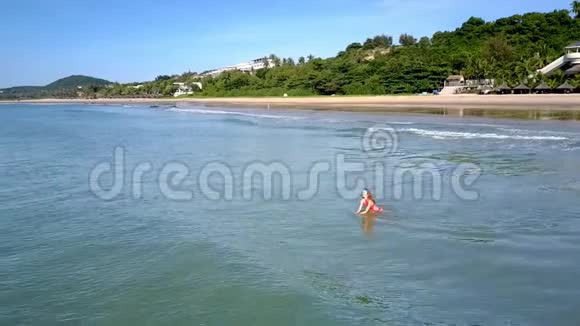 少女在平静的海浪中拍打棕榈滩视频的预览图