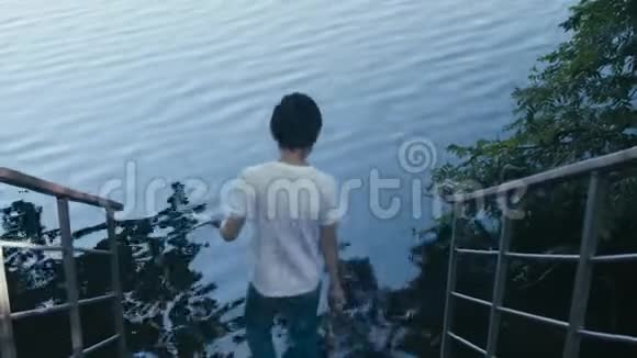 那个男孩把鹅卵石扔进水里视频的预览图