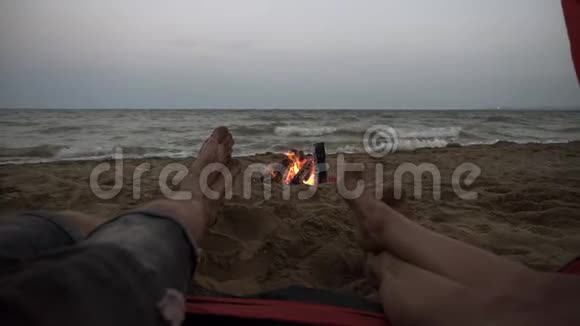 拍摄了年轻人从海滩上的红色帐篷脚的特写镜头有海景的男女腿视频的预览图