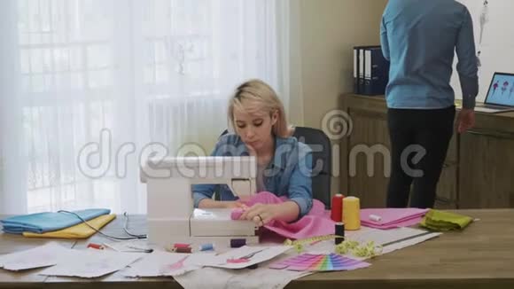 女裁缝在她的工作室里用缝纫机工作视频的预览图