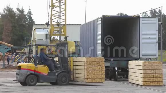 叉车在铁路车的背景下运输木板铁路货车装载木材视频的预览图