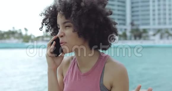 在外面打电话的漂亮的种族女孩视频的预览图