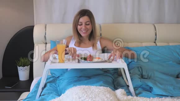 吃早餐香肠的女人躺在床上视频的预览图