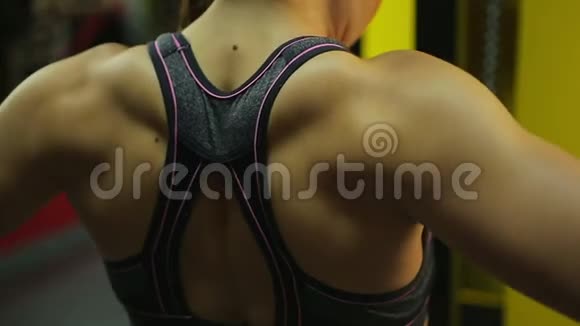 健身运动中肌肉女运动员背部的特写镜头视频的预览图