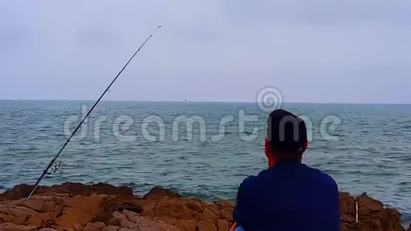 一个人坐在岩石上眺望大海视频的预览图