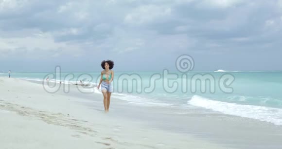 在热带海岸线上奔跑的快乐女孩视频的预览图