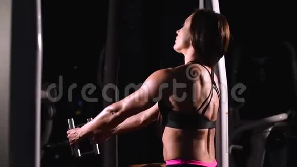 一个强壮肌肉发达运动健美的女孩穿着短裤在水平模拟器上训练背部肌肉视频的预览图