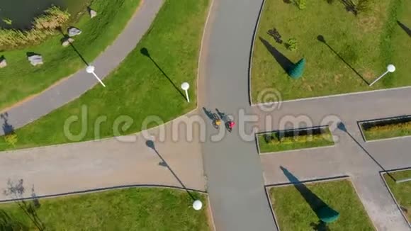 两个小男孩在公园骑自行车的空中镜头视频的预览图