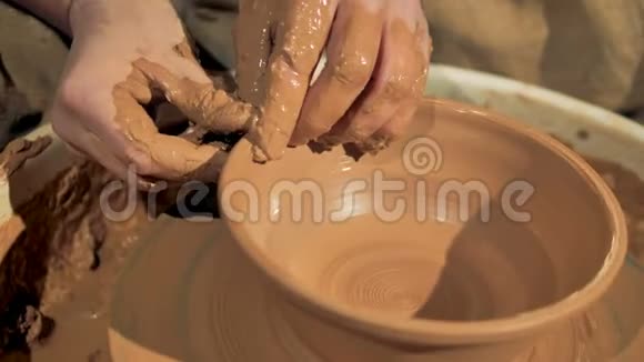 陶工的手在轮子上形成一个碗的边缘视频的预览图