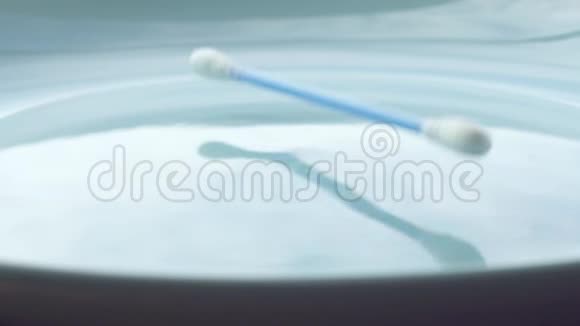 蓝色棉棒滴在蓝色盘子里视频的预览图