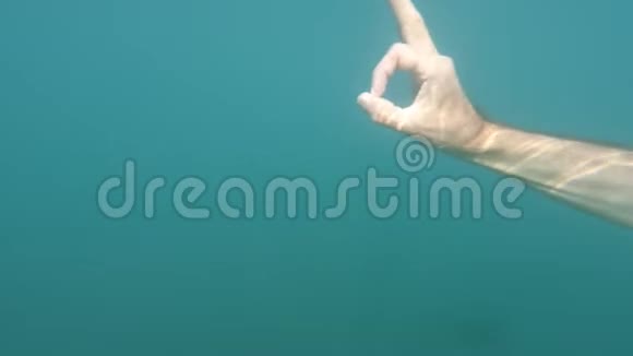 男性手显示拇指向上和OK标志手势在蓝色水下背景与气泡手势和手势身体视频的预览图