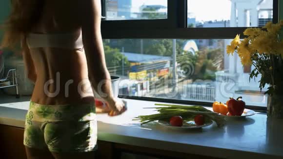 女孩切块把番茄放进窗户的锅里视频的预览图
