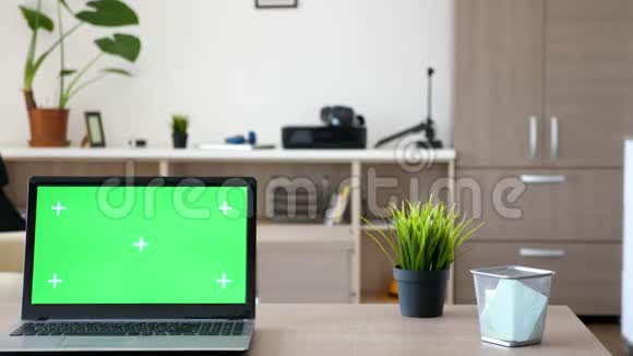 带有绿色屏幕的笔记本电脑模拟在客厅中间的桌子上视频的预览图