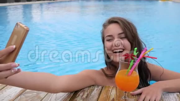 穿泳衣的女孩在泳池边用五颜六色的饮料拍照视频的预览图