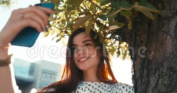 年轻迷人的黑发美女迷人的微笑正在阳光公园自拍4K录像视频的预览图