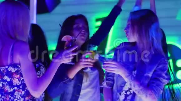 朋友聚会女孩端着酒杯喝着酒在舞池里跳舞视频的预览图