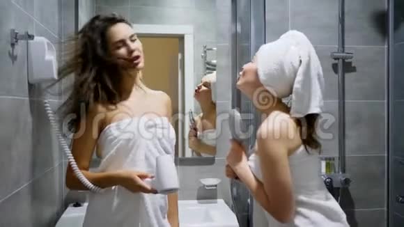 派对上的女生魅力朋友裹着毛巾在淋浴的背景下唱歌跳舞视频的预览图