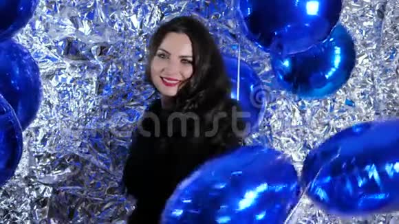 节日的女士真诚的微笑在充气气球的背景上灿烂的墙壁装饰箔视频的预览图