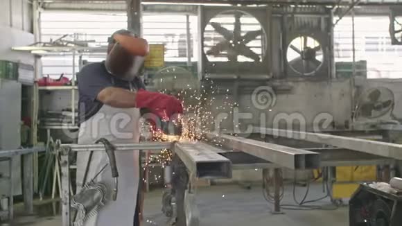 一名工人在金属车间使用带有火花的金属磨床缓慢移动视频的预览图