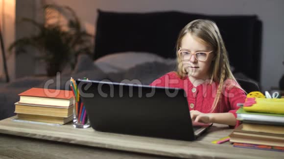 在家的笔记本电脑上微笑着上学女孩上网视频的预览图