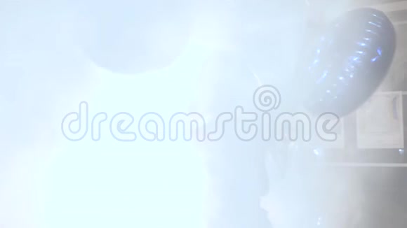 夜晚的生活开朗的黑发女人带着明亮的充气球在背光的烟雾中拥入怀中视频的预览图