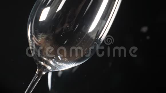 黑色背景上的玻璃红酒正缓慢地涌入酿酒厂泼酒高清高清视频的预览图