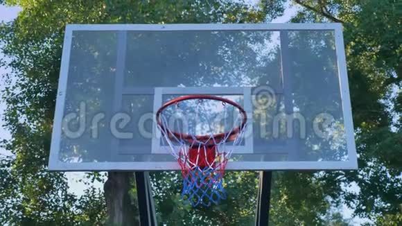 篮球缺环球员未能通过篮圈击球在公园露天比赛白天视频的预览图