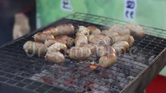 在街头市场的露天煤火上煮猪肉肉香肠视频的预览图
