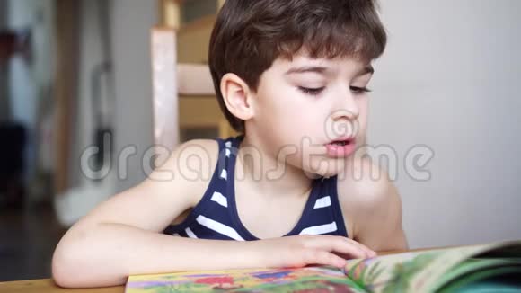 可爱的6岁男孩读书吃干果视频的预览图