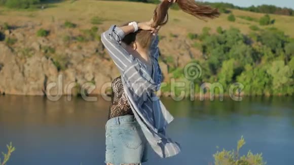 幸福的微笑女孩站在一个大湖的背景下视频的预览图