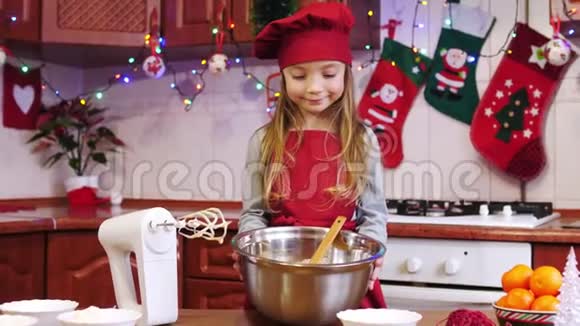 可爱的厨师女孩在镜头前展示碗里的面团的肖像视频的预览图