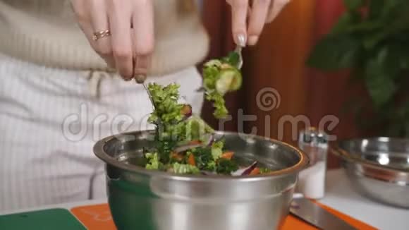 女人在碗碟里拌蔬菜沙拉混合素食沙拉的成分蔬菜沙拉的准备视频的预览图