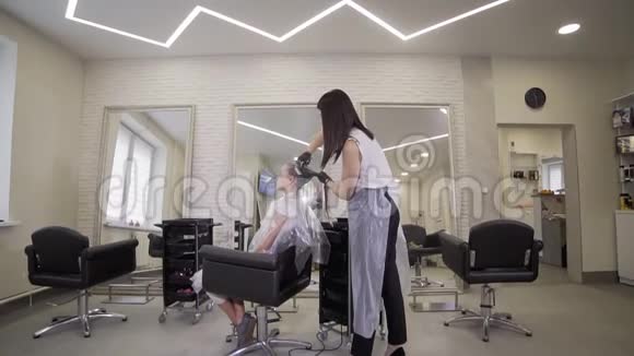 发型师使用染发剂来减轻发色视频的预览图