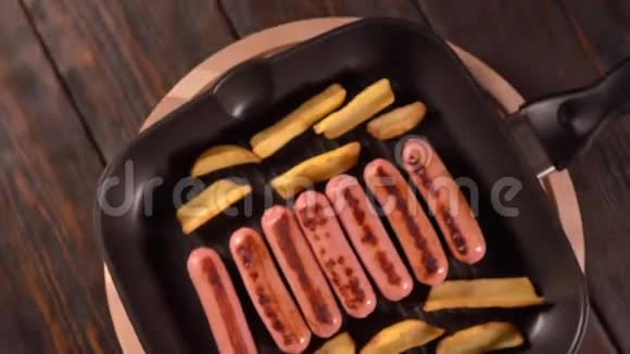 烤盘上的土豆楔子和煮熟的香肠视频的预览图