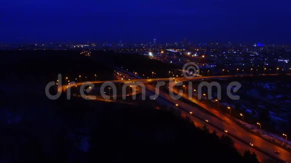在充满汽车和卡车的夜晚一个大的照明道路交叉口的空中景观视频的预览图