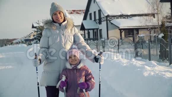 妈妈和女儿看着相机在冬天北欧人在郊区散步之前微笑视频的预览图