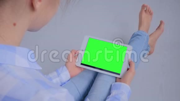 女人看着空白绿色屏幕的平板电脑模拟概念视频的预览图