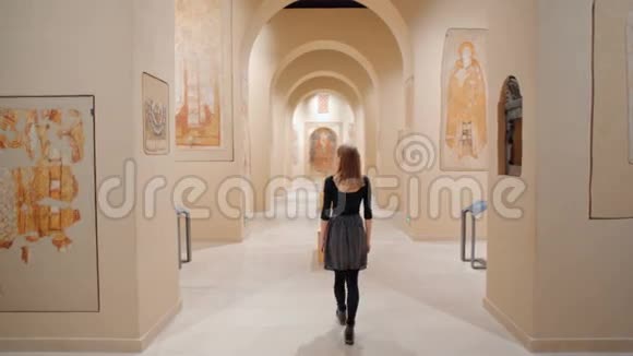 苗条的年轻女士正在参观博物馆看墙上的Fresco视频的预览图