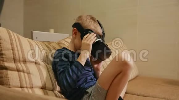 男孩67年在家玩借助虚拟现实护目镜的电子游戏特写视频的预览图