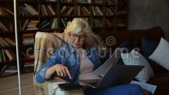 令人愉快的退休妇女在家里做财务规划视频的预览图