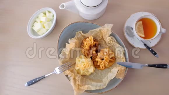 朱莉安用面团在面包纸上的盘子里烤上面有茶和黄油上景视频的预览图